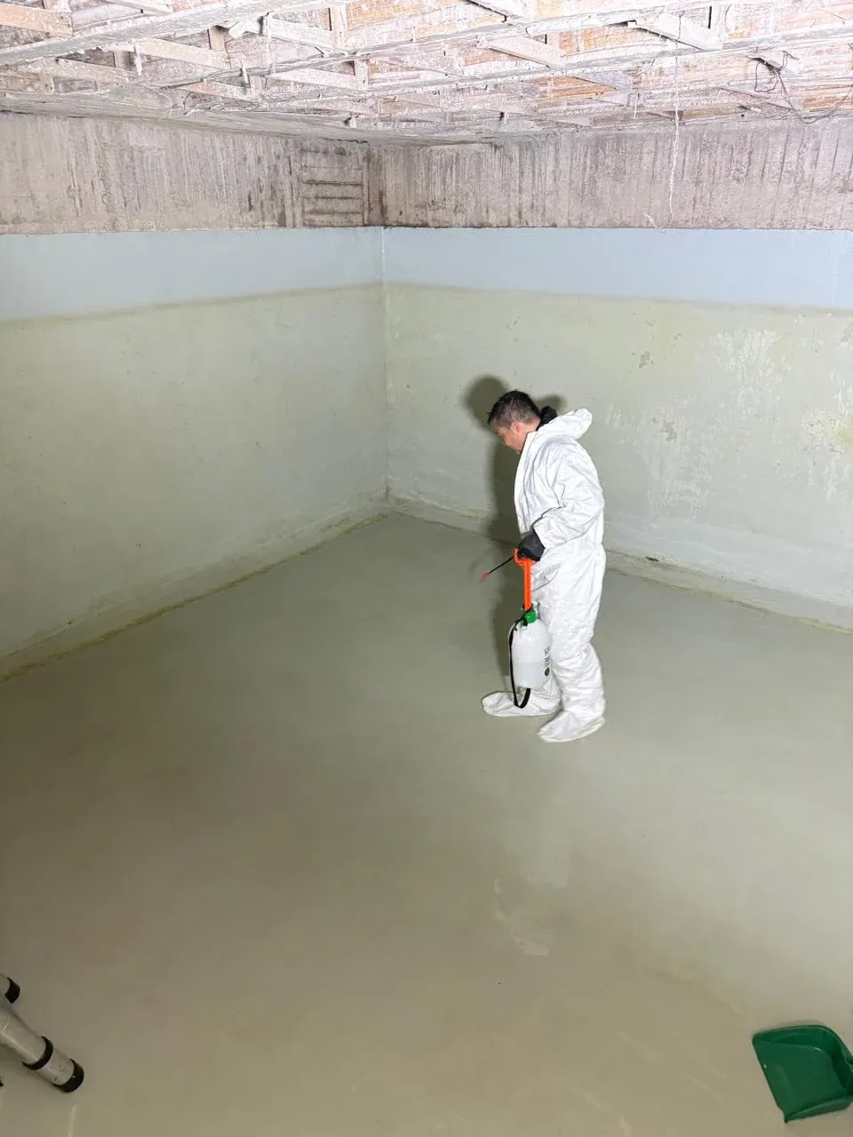 Técnico con traje blanco desinfectando el interior de un tanque de agua potable en Bogotá