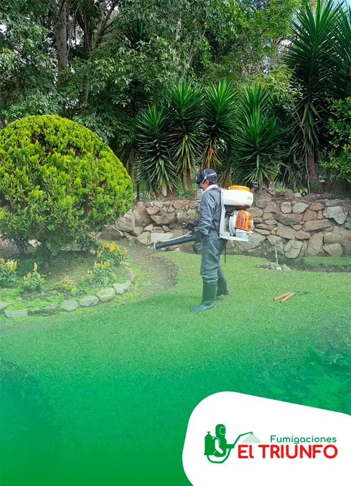 Técnico fumigando el jardín de una casa en Bogotá con equipo de protección
