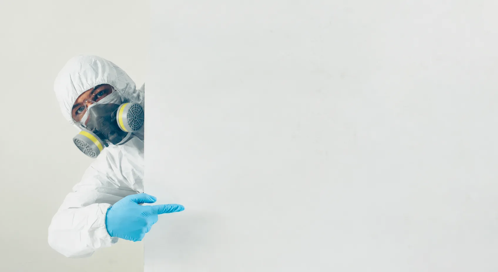 Técnico con traje de protección y respirador señala los servicios de fumigación en Bogotá